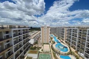 Vistas al mar de un gran edificio de apartamentos con piscina en Apart Hotel Garden Secret Tagua Life, en Brasilia