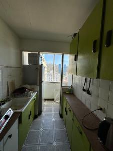 a small kitchen with green cabinets and a window at Departamento centro de Viña in Viña del Mar