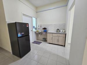 a kitchen with a black refrigerator in a room at Valerie Homestay in Sandakan