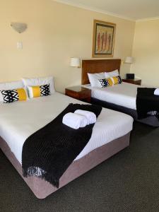 a hotel room with two beds with towels on them at Armidale Pines Motel in Armidale