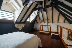 um quarto com uma cama branca num sótão em Villa Créole Confortable avec vue sur lagon em Sainte-Rose
