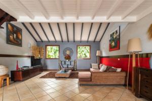 uma sala de estar com um sofá e uma mesa em Villa Créole Confortable avec vue sur lagon em Sainte-Rose