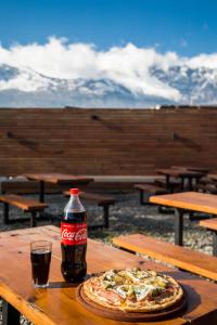 a bottle of coke and a pizza on a table at Big Hostel in El Bolsón