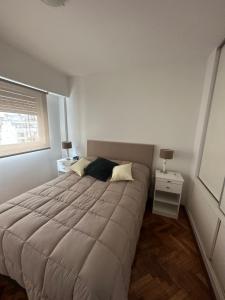 Un dormitorio con una cama grande y una ventana en CorrientesNice en Buenos Aires