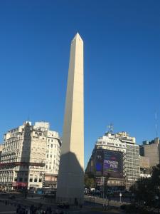 a tall white tower in a city with buildings at CorrientesNice in Buenos Aires