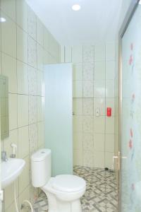 La salle de bains est pourvue de toilettes et d'un lavabo. dans l'établissement grand koetaradja permai hotel, à Luengbata