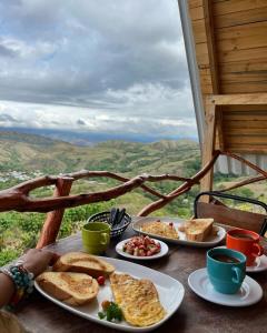 une table avec des assiettes de nourriture au sommet d'une montagne dans l'établissement Los Nevados Ecolodge, à Gigante