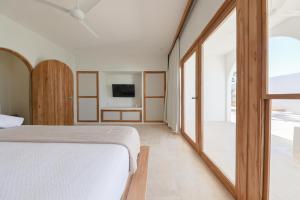 a bedroom with a bed and a large window at Hide and Seek Resort in Popoyo