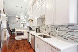 a kitchen with white cabinets and a sink at Amazing 3bedroom townhome, in Historic Dryade City in New Orleans