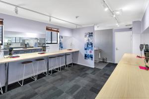 a kitchen with white walls and bar stools at Gilligan's Hotel & Resort Cairns in Cairns