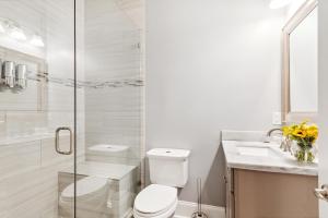 a white bathroom with a toilet and a sink at Amazing 3bedroom townhome, in Historic Dryade City in New Orleans