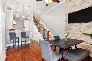 a dining room with a table and chairs and a brick wall at Amazing 3bedroom townhome, in Historic Dryade City in New Orleans