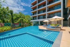 a swimming pool in front of a building at Grand Kata VIP - Kata Beach in Kata Beach