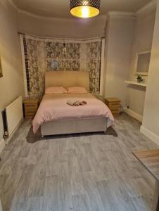 1 dormitorio con 1 cama con sábanas rosas y suelo de madera en ArklesFCLiverpool, en Liverpool