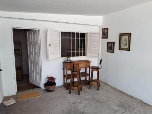 a room with a desk and a window and chairs at La Mora Departamento in Mina Clavero
