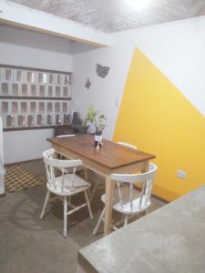 a dining room with a wooden table and two chairs at CASITA PINTORESCA EN LAS SIERRAS Y LAGO in San Roque