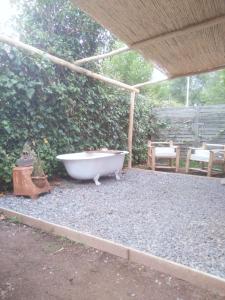 uma banheira sentada sob um pavilhão num quintal em CASITA PINTORESCA EN LAS SIERRAS Y LAGO em San Roque