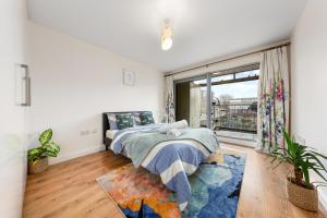 a bedroom with a bed and a large window at Modern Spacious 1 Bedroom Flat in Camden in London