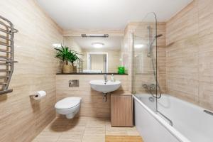 a bathroom with a sink and a toilet and a tub at Modern Spacious 1 Bedroom Flat in Camden in London