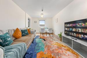 a living room with a couch and a flat screen tv at Modern Spacious 1 Bedroom Flat in Camden in London