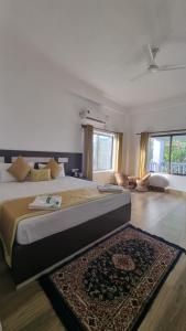 カジランガにあるShivaji Inn Kazirangaのベッドルーム1室(大型ベッド1台、ラグ付)