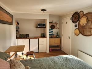 a bedroom with a bed and a table and a kitchen at 'Haumoana' in Olde Beach. in Waikanae