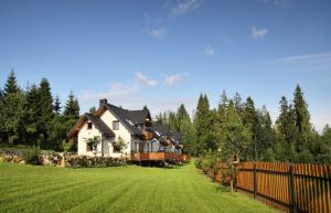 a house in the middle of a yard with a fence at Domek Buflak in Nowy Targ