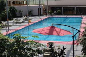 Huayin的住宿－华山欣源国际酒店，一座大型游泳池,里面装有粉红色的遮阳伞