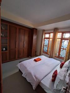 a bedroom with a large white bed with wooden cabinets at Snowline Homestay in Kīar