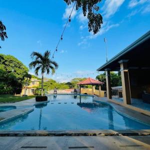 una piscina con cenador y palmeras en Villas jr estudio 1 by Oasis Guacalillo, en Tarcoles