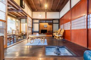 白山市囲炉裏町家Guesthouse FUJITA 一棟貸切 villa 無料駐車場的一个带桌椅的大客厅
