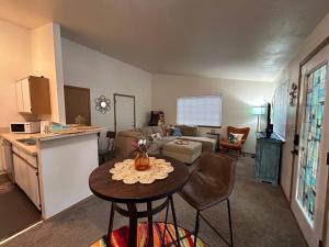 a living room with a couch and a table and a kitchen at Retro Oasis • Ms. Pac-Man • 2BR • Parking • Boise in Boise