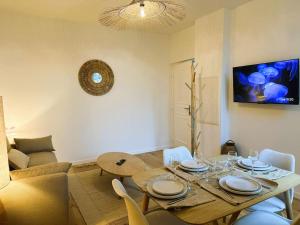 a dining table and chairs in a living room at L'Escapade des Privilégiés in Amiens +24 photos