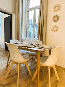 a dining room with a table with wine glasses on it at L'Escapade des Privilégiés in Amiens