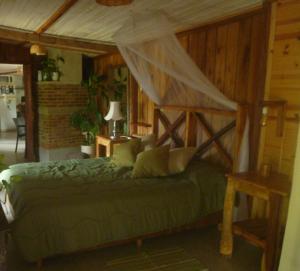 a bedroom with a green bed with a canopy at Quindio in Barra del Chuy
