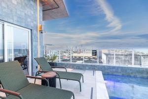 a balcony with chairs and a swimming pool on a building at Place2You Hotel by Welkom in João Pessoa