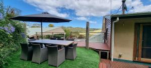 a table and chairs with an umbrella on a deck at Eastern Reef Cottages in Port Campbell