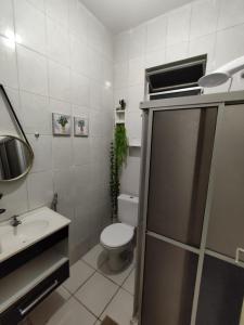 a white bathroom with a toilet and a sink at Ap8 atrás da Passarela do caranguejo- Orla de Atalaia in Aracaju