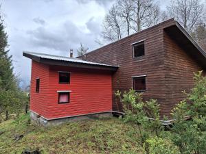 una casa roja al lado de una colina en Cabaña en Caburgua, Pucon, en Pucón