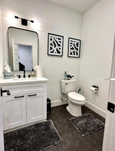 uma casa de banho branca com um WC e um espelho. em Downtown Houston House em Houston