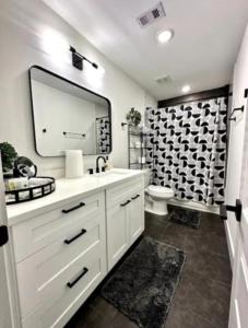 uma casa de banho com um lavatório, um espelho e um WC. em Downtown Houston House em Houston