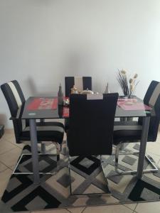 una mesa de comedor con 4 sillas alrededor en Chez Catherine et Pierre en Juvigny-le-Tertre