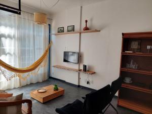 a living room with a couch and a tv on a wall at URCA 303 Rio BR in Rio de Janeiro