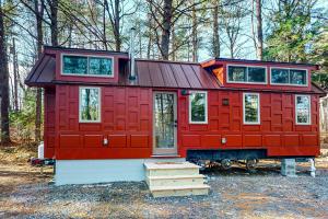 a red cabin in the middle of a forest at Thainy House in Gardiner