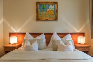 a bedroom with a bed with white pillows and two lamps at P4W Hotel Residence Szombathely in Szombathely