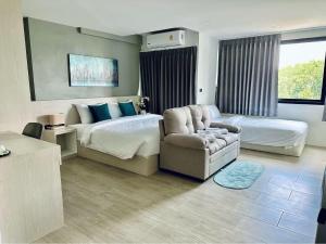 a hotel room with a bed and a chair at Aston Residence Hatyai 