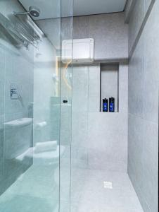 La salle de bains est pourvue d'une douche avec une porte en verre. dans l'établissement Place2You Hotel by Welkom, à João Pessoa