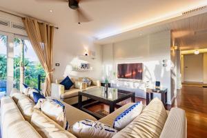 a living room with a couch and a tv at 3BR Casa Azul - Beachfront Home in Laguna & Layan Chom Tawan and Maan Tawan Residences in Phuket Town