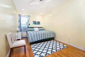 a bedroom with a bed and a chair and a rug at A Slice of Paradise vacation rental in Brooklyn