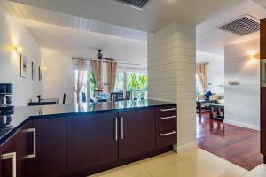 a kitchen with brown cabinets and a counter top at 3BR Family Home in Laguna — 100m walk from beach in Phuket Town